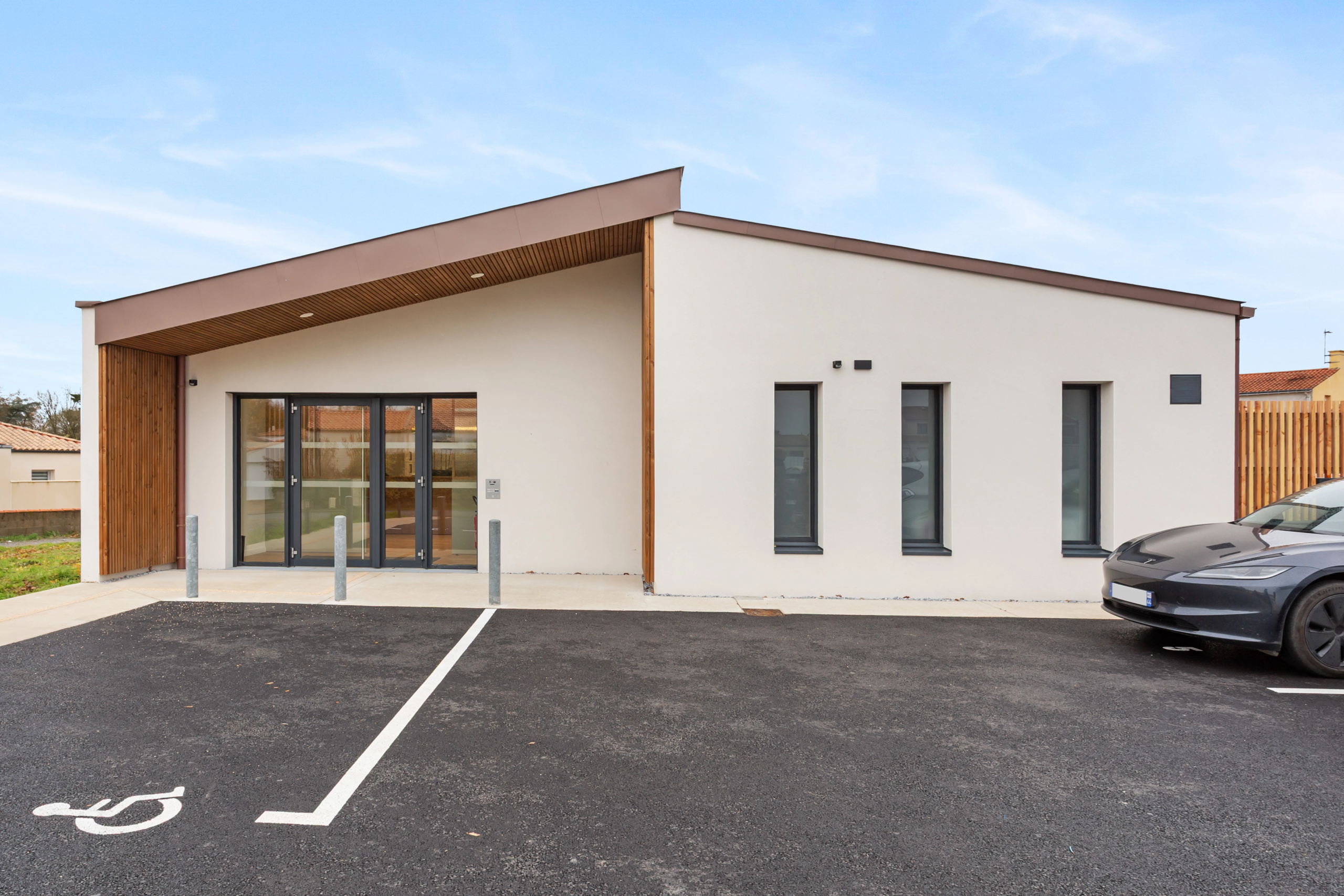 Bâtiment moderne avec bardage bois et parking accessible