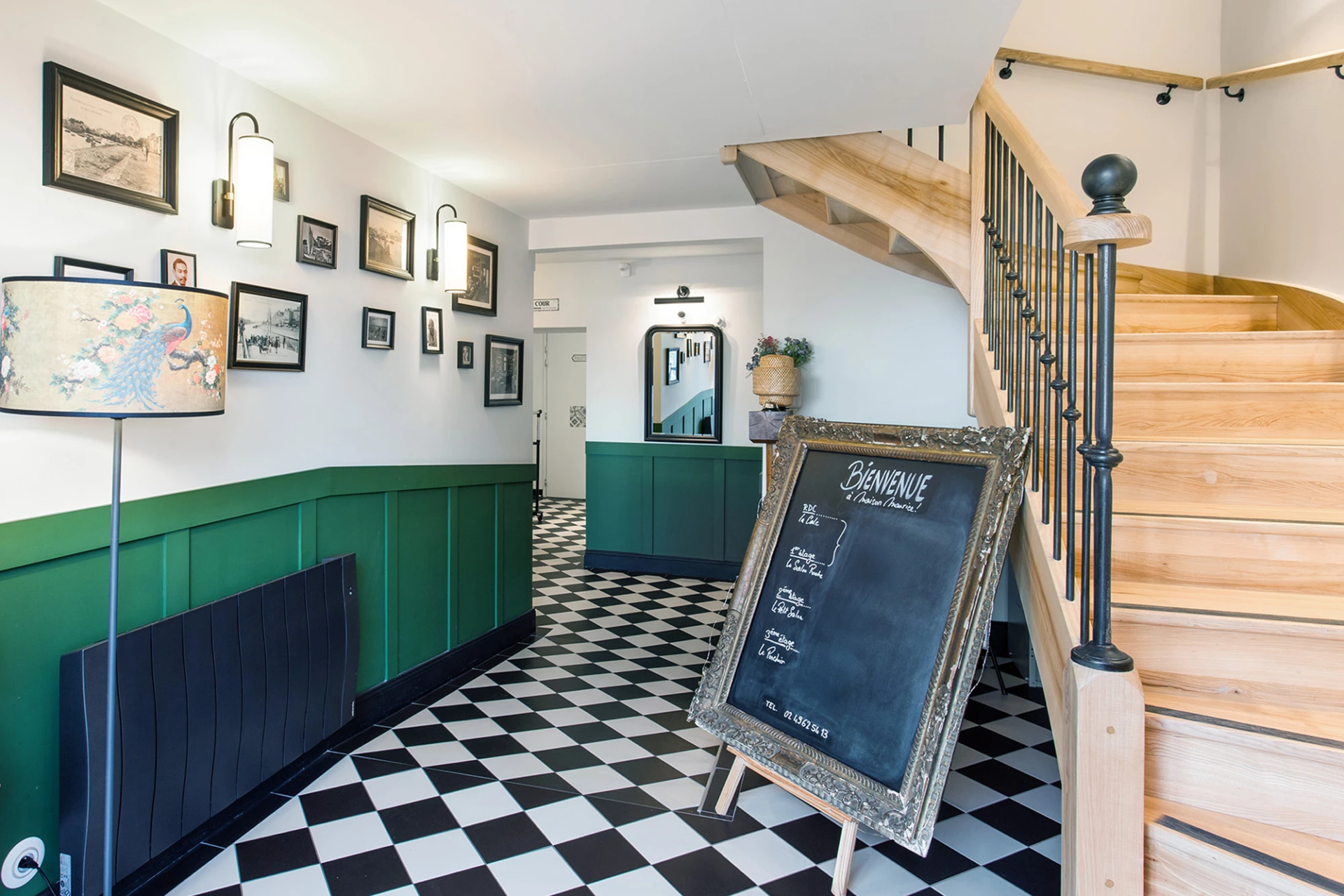 Entrée avec escalier en bois sol damier et panneau bienvenue