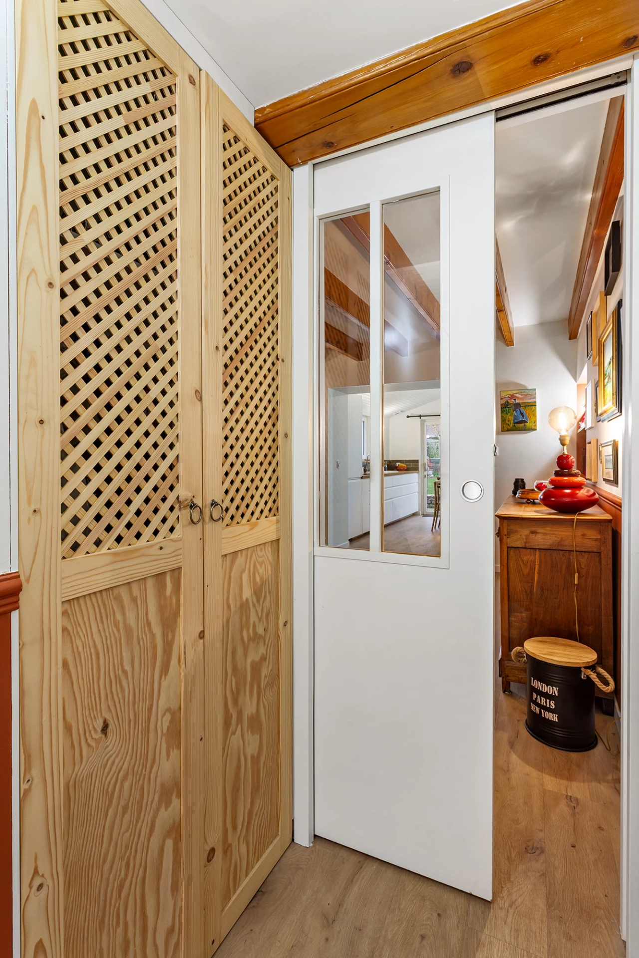 Porte coulissante blanche avec vitrage et placard en bois ajouré