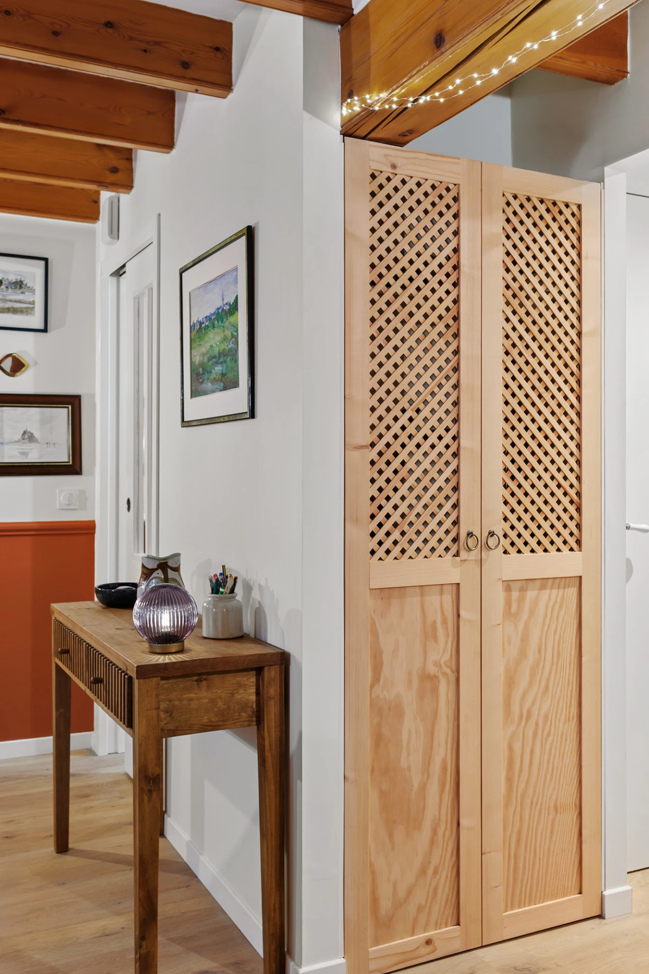 Placard en bois clair avec portes ajourées dans un couloir