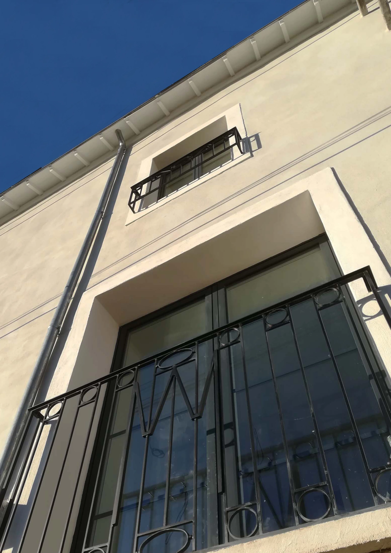 Façade de bâtiment avec balcon métallique noir vu en contre plongée
