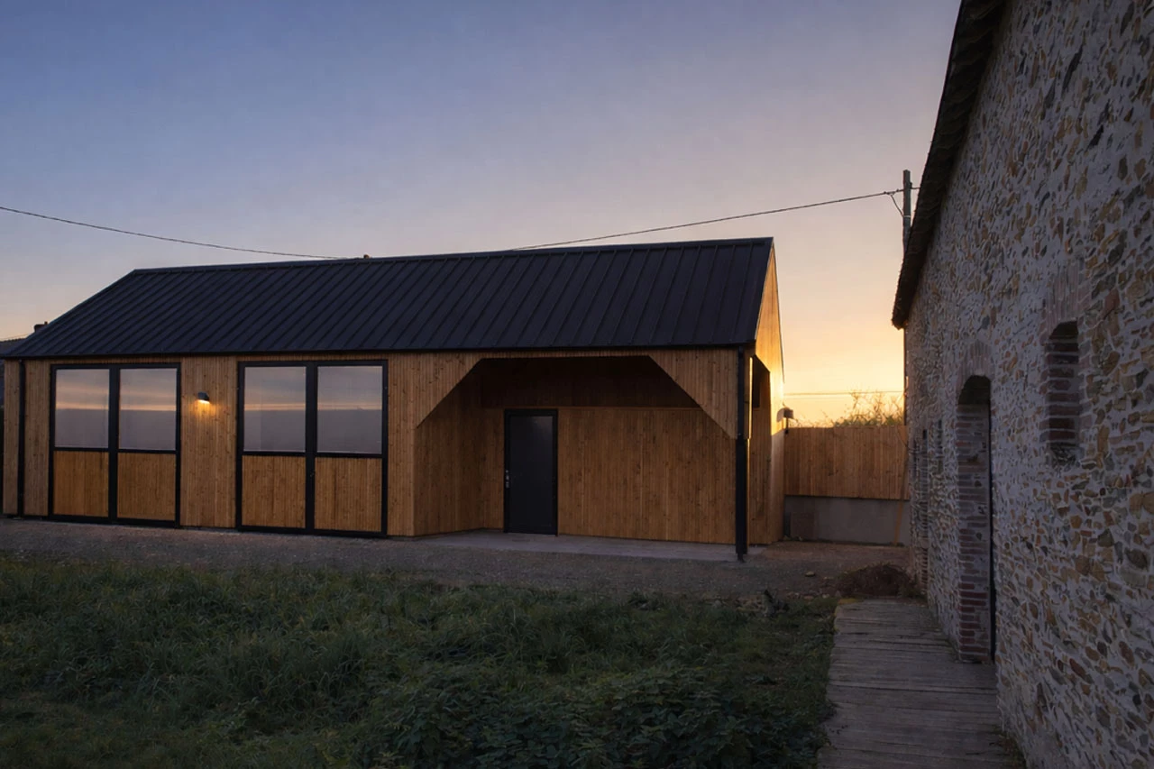 Bâtiment en bois moderne avec toiture métallique au crépuscule