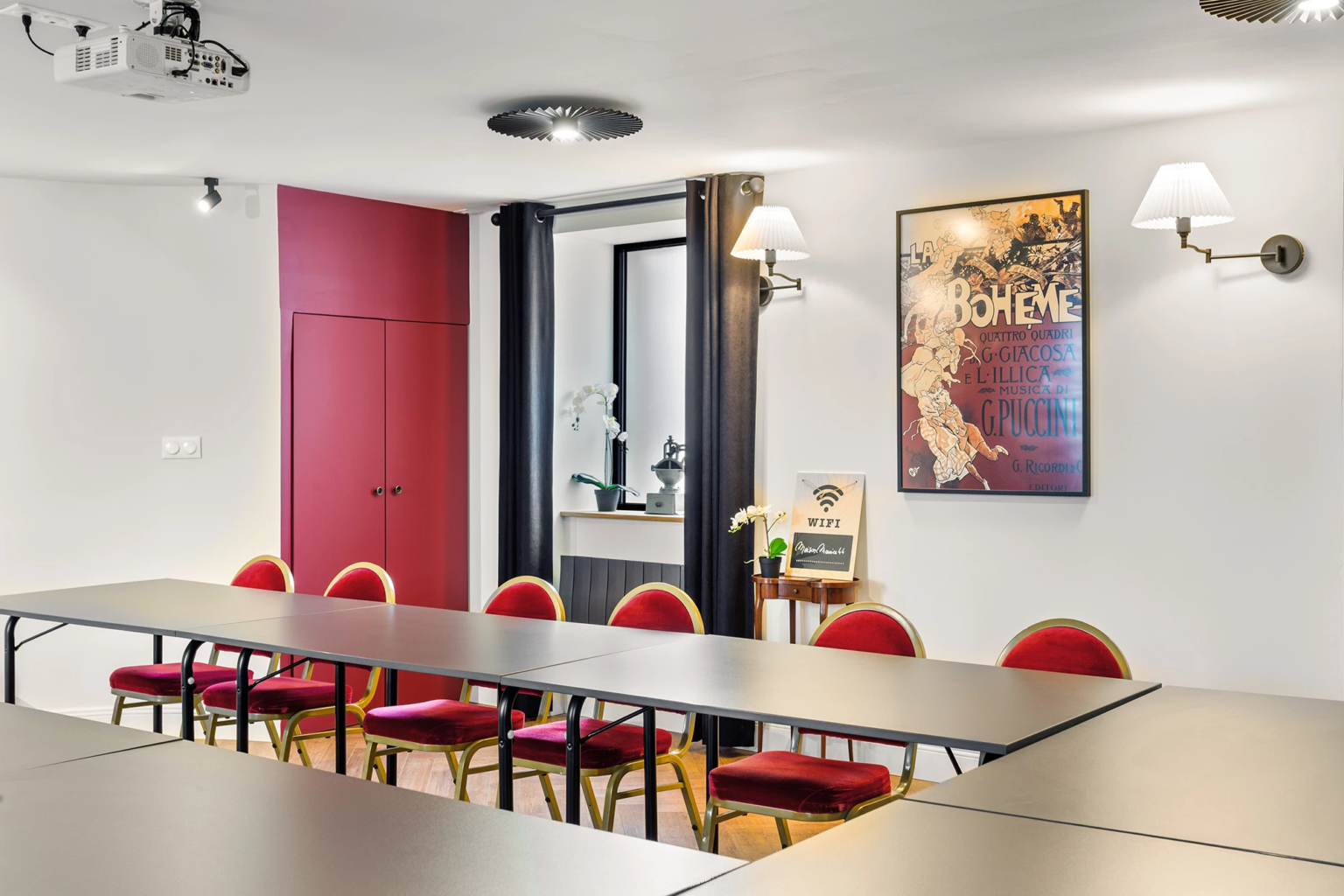 Salle de réunion avec tables grises et chaises rouges