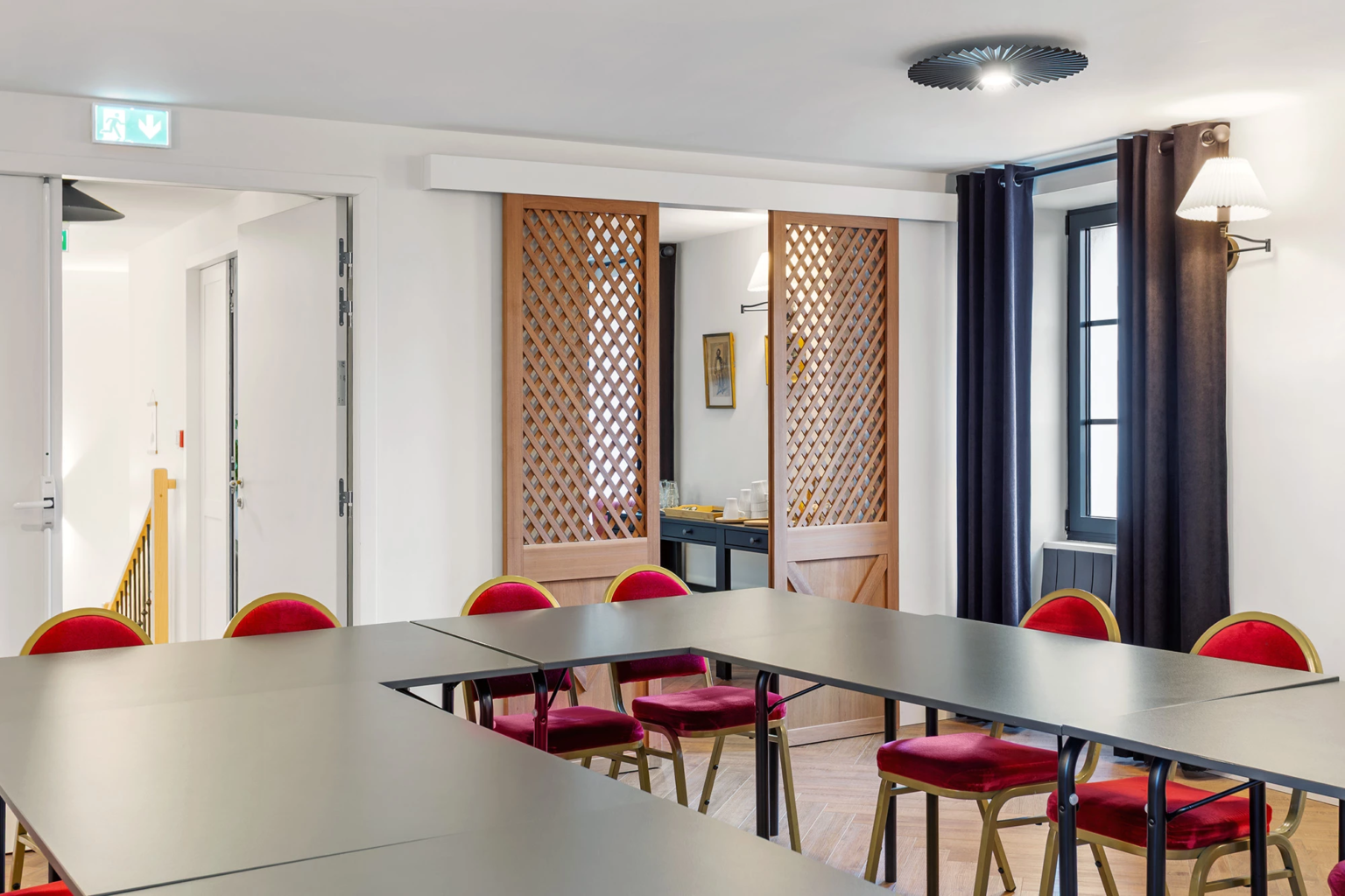 Salle de réunion avec cloisons en bois ajouré et tables