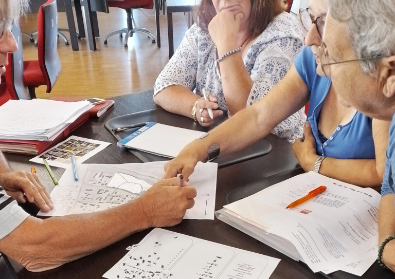 Adultes réunis autour de plans et documents sur une table