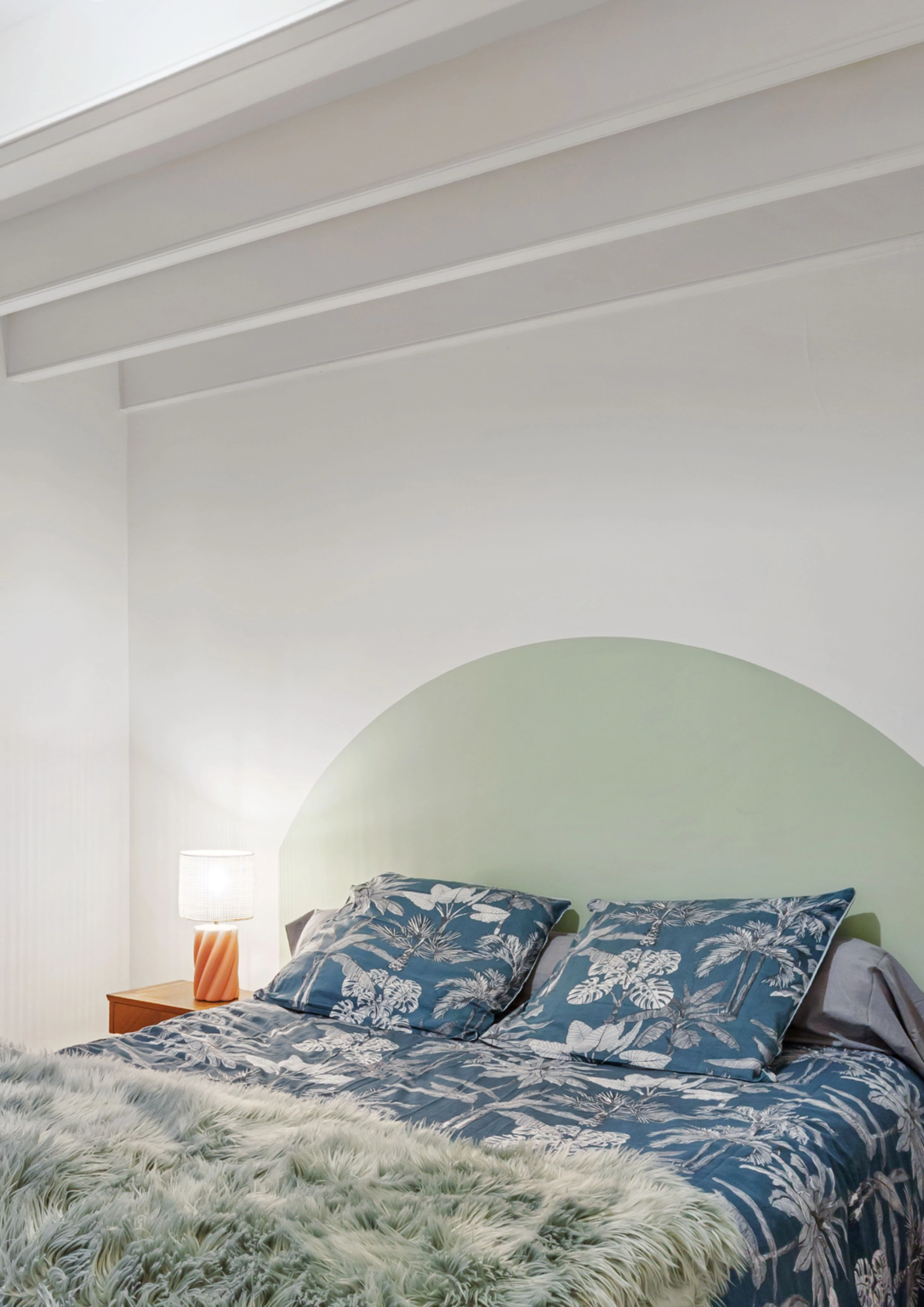 Chambre avec lit double linge bleu et tête de lit arrondie