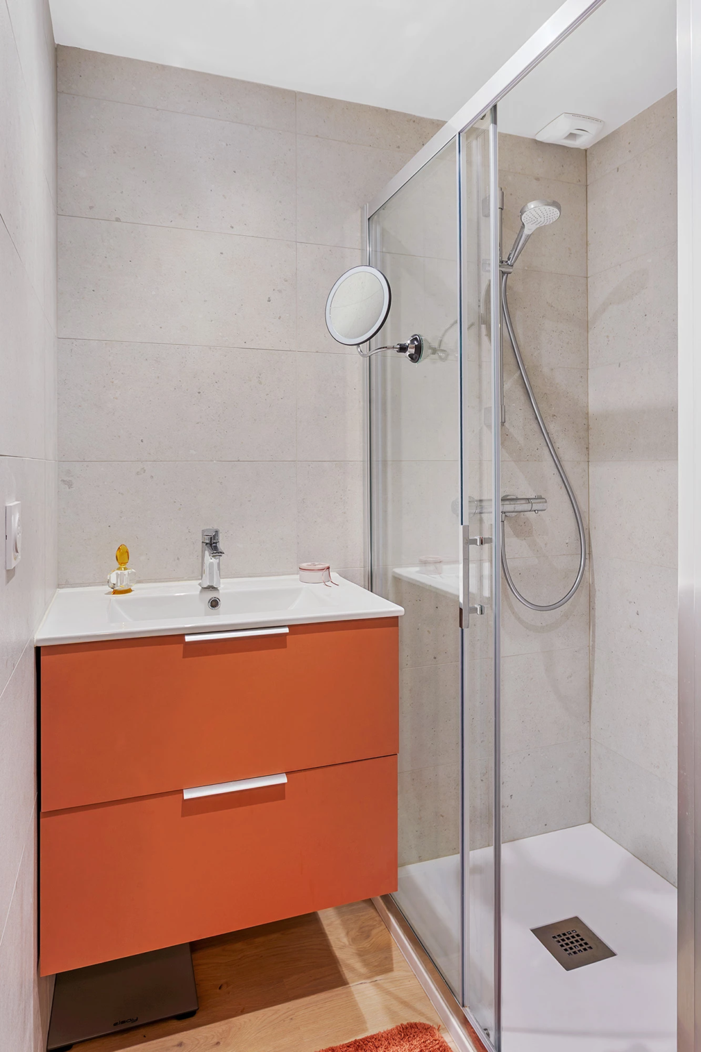 Salle de bain avec meuble vasque orange et douche vitrée